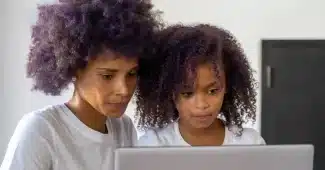 Parent et adolescent travaillant ensemble sur des routines visuelles et des pictogrammes à la table