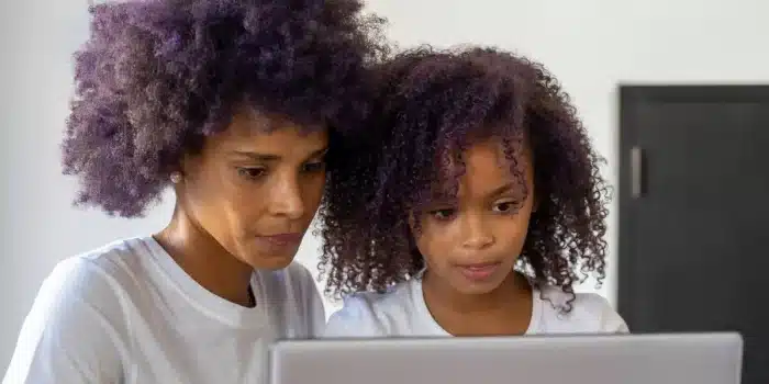 Parent et adolescent travaillant ensemble sur des routines visuelles et des pictogrammes à la table