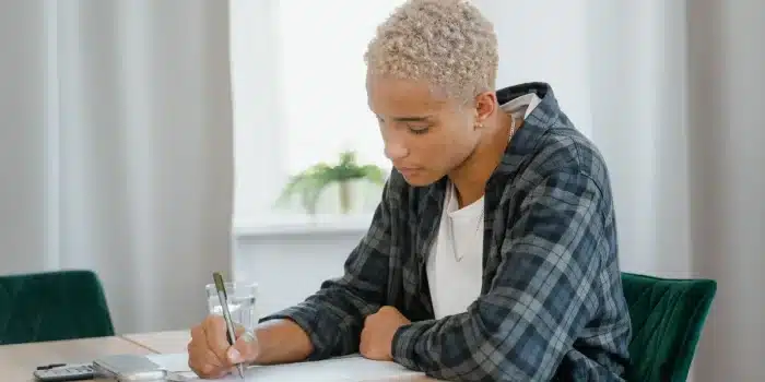 Adolescent et accompagnant travaillant ensemble sur une tâche quotidienne avec des supports visuels illustrés