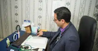 Parent et adolescent en consultation médicale avec documents de suivi
