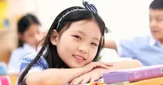 Enfant à son bureau scolaire avec un inhalateur à proximité et ses fournitures de classe