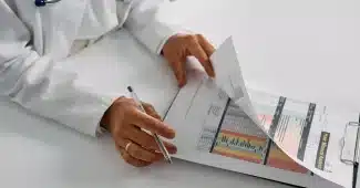 Travailleur consultant des documents professionnels et dossiers de santé à son bureau
