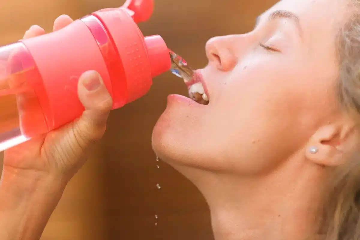 Femme buvant régulièrement de l'eau pour maintenir une bonne hydratation