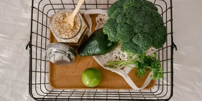 Assiette de légumes frais et aliments sains près d'une balance sur un plan de travail