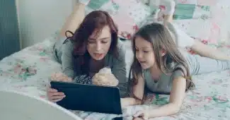 Parent et enfant en conversation autour d'une tablette numérique