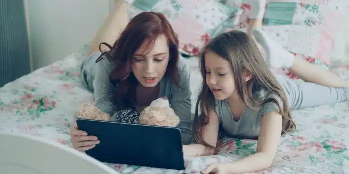 Parent et enfant en conversation autour d'une tablette numérique
