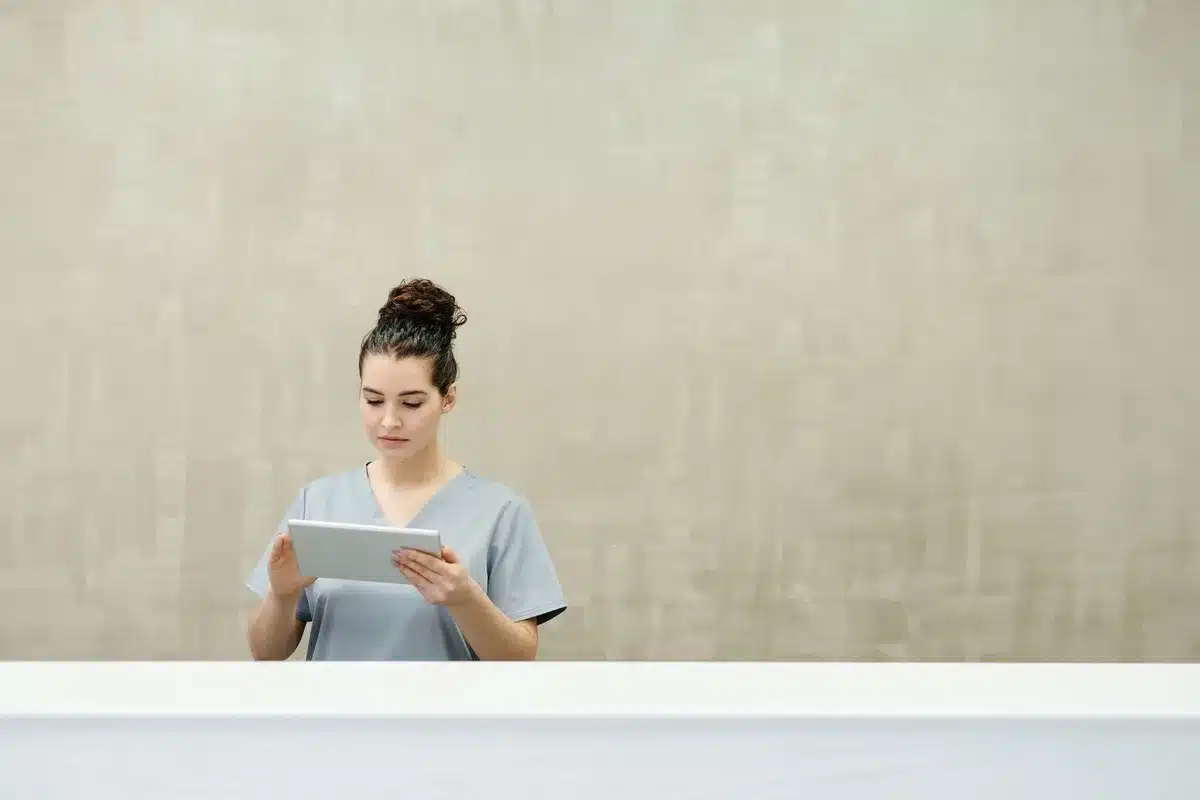 Femme lisant attentivement des informations médicales sur une tablette numérique
