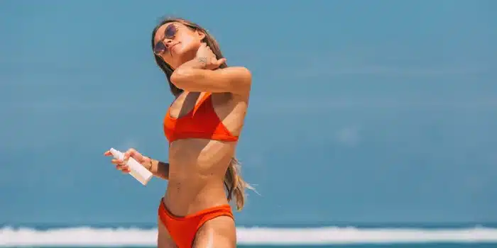 Application de crème solaire sur un bras à la plage en été