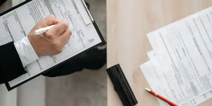 Documents administratifs et dossiers médicaux organisés sur un bureau avec un stylo