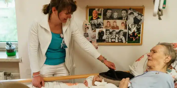 Soignant prenant des notes au chevet d'un patient la nuit pour préparer une consultation médicale