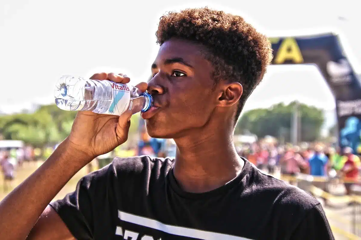 Sportif buvant régulièrement de l'eau avant et pendant l'entraînement