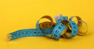 Illustration montrant une personne mesurant son tour de taille avec un mètre, symbolisant le lien entre surpoids et risq