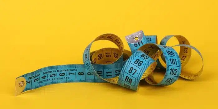 Illustration montrant une personne mesurant son tour de taille avec un mètre, symbolisant le lien entre surpoids et risq
