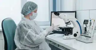 Chercheur observant des cellules neuronales au microscope en laboratoire.