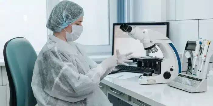 Chercheur observant des cellules neuronales au microscope en laboratoire.