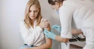 Professionnel de santé recevant une injection de vaccin contre la grippe en établissement de soins
