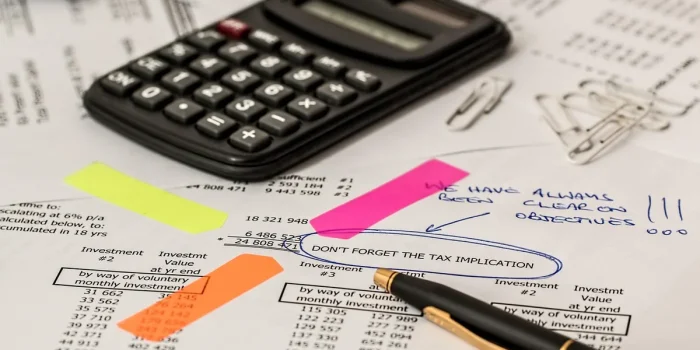 Documents d'assurance santé et formulaires administratifs sur un bureau avec un ordinateur portable