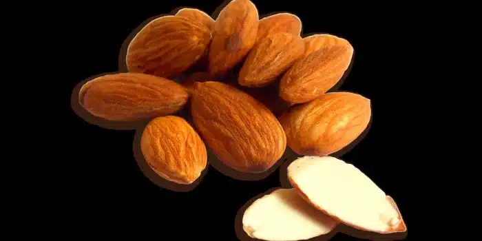 Aliments riches en magnésium : amandes, graines et légumes verts sur une surface neutre