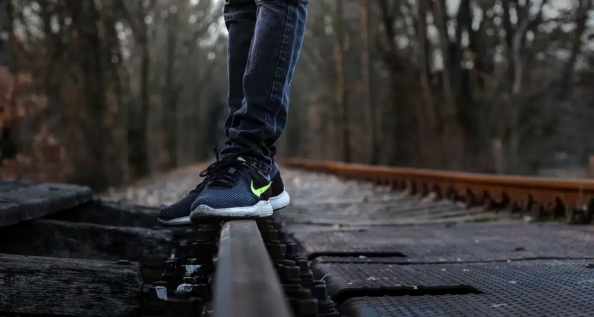 Personne vérifiant ses chaussures sur un palier avant de monter des escaliers