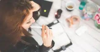 Espace de travail lumineux avec ordinateur portable, carnet et portfolio de projets sur une table