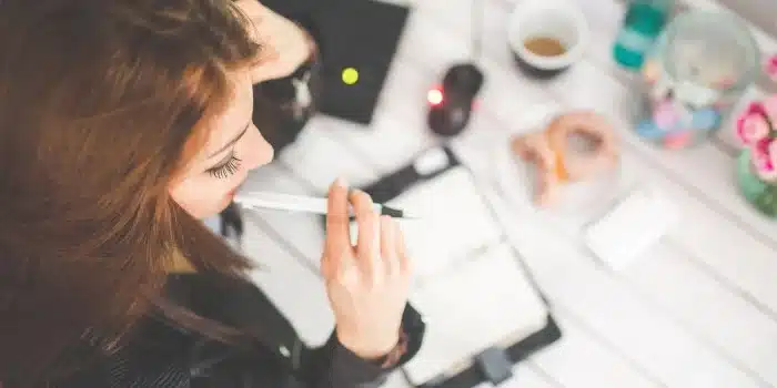 Espace de travail lumineux avec ordinateur portable, carnet et portfolio de projets sur une table