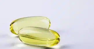 Gélules probiotiques et pilules congelées sur une table, flou d'un laboratoire en arrière-plan