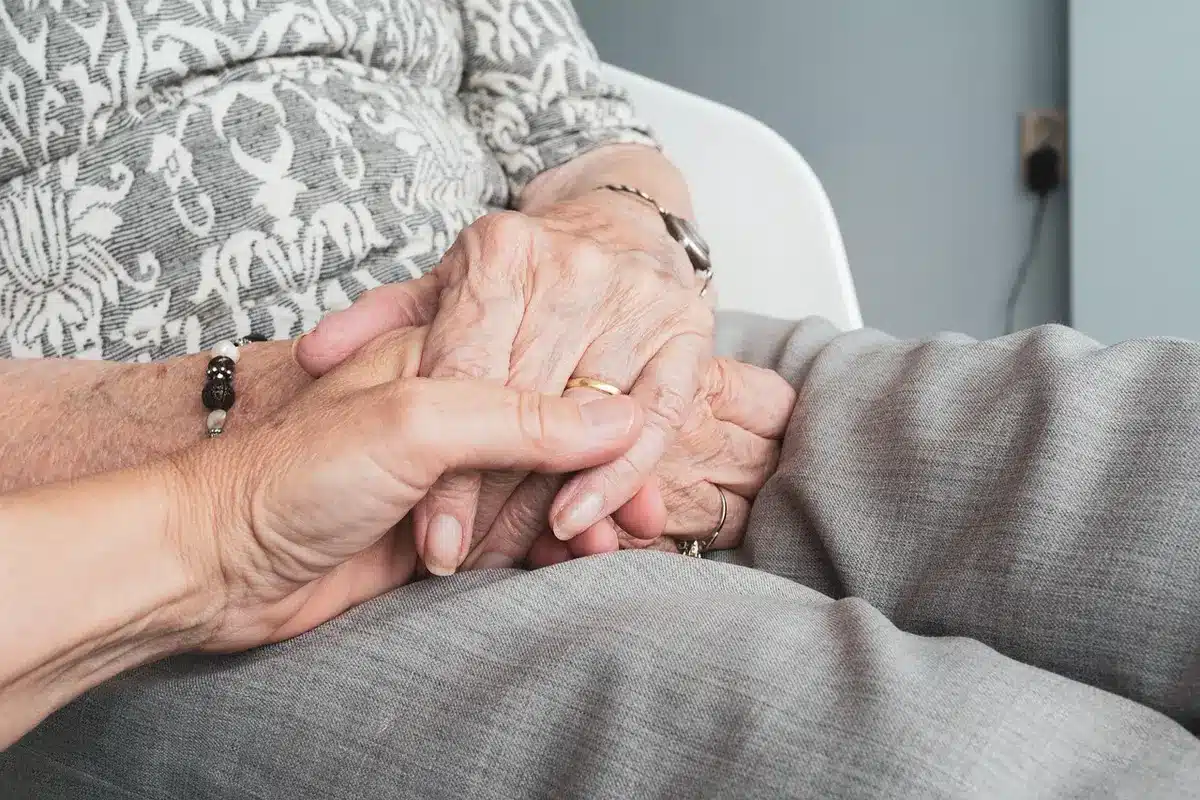 Chambre claire montrant un lit et un fauteuil dans un environnement de soins