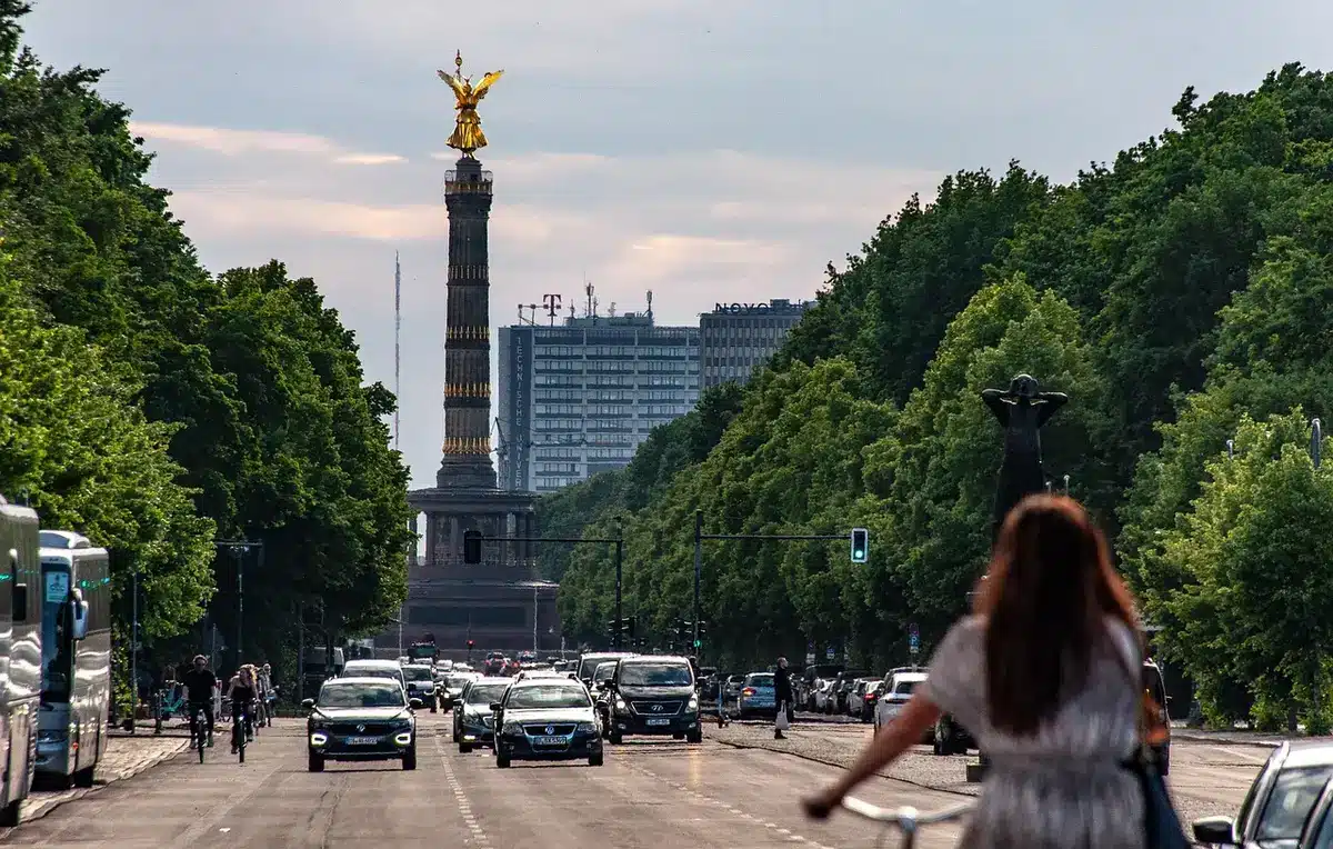 Espace vert urbain avec arbres et bancs où le chant d'oiseaux est audible