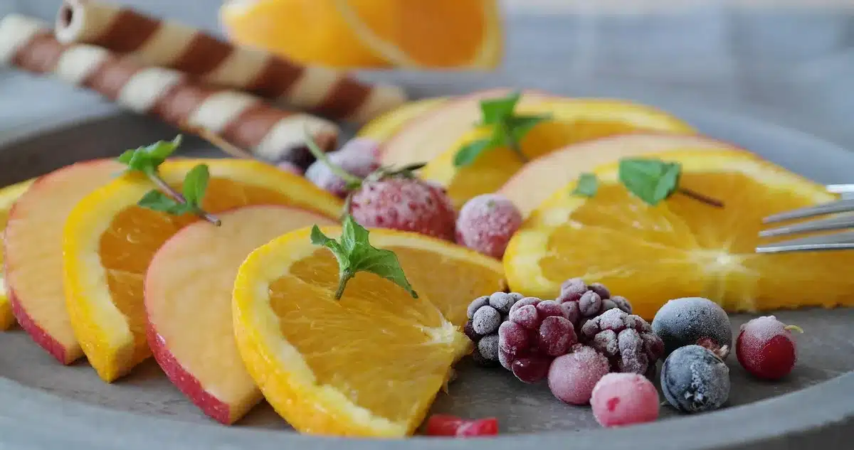 Assiette avec portions enrichies et petite collation protéinée sur une table claire