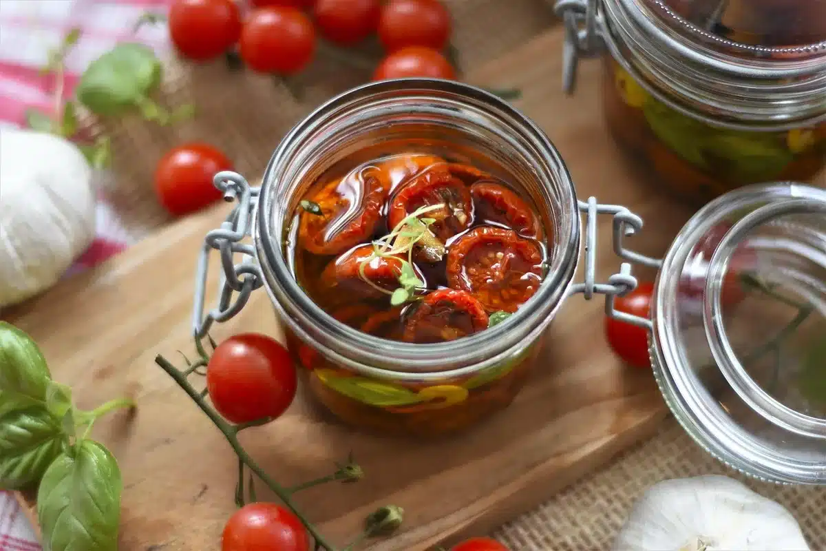 Filet d'huile d'olive versé sur une salade ou plat à base de tomate pour améliorer l'absorption