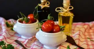 Tomates coupées sur une planche avec un filet d'huile d'olive dans une cuisine en lumière du jour