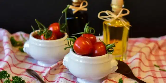 Tomates coupées sur une planche avec un filet d'huile d'olive dans une cuisine en lumière du jour