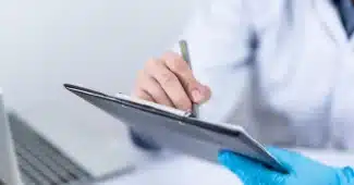 Accueil lumineux d’un cabinet médical avec documents et mains d’un praticien et d’un patient