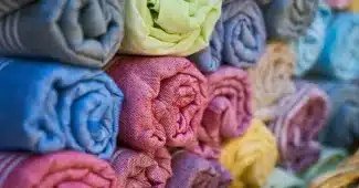 Sous‑vêtements en coton et crème émolliente sur une étagère de salle de bain en pleine journée