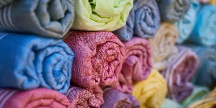 Sous‑vêtements en coton et crème émolliente sur une étagère de salle de bain en pleine journée