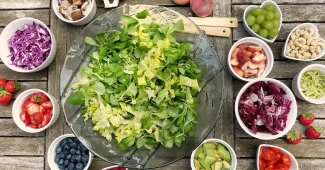 Bol de repas végétal sur une table de cuisine lumineuse, mains anonymes à proximité