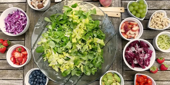 Bol de repas végétal sur une table de cuisine lumineuse, mains anonymes à proximité