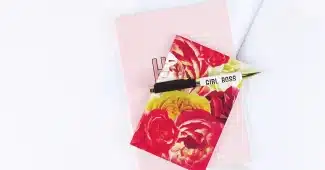 Montre connectée posée sur une table près d'une fenêtre, carnet et stylo à côté