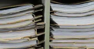 Personne anonyme consultant des dossiers sur une table de bureau en journée
