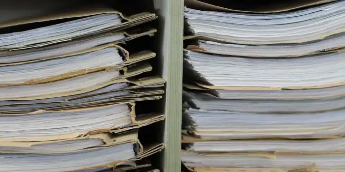 Personne anonyme consultant des dossiers sur une table de bureau en journée