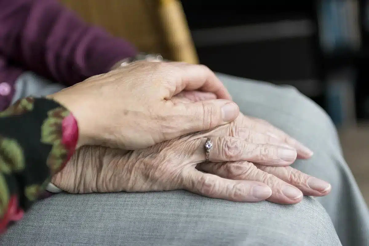 Aidant montrant l'utilisation d'un dispositif à une personne âgée